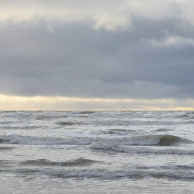 Fırtınadan sonra Baltık Denizi. Yumuşak günbatımı ışığı, çarpıcı parlayan bulutlar. Deniz manzarası, bulutlar, doğa. Panoramik manzara. Ekoloji, iklim değişikliği, hava durumu