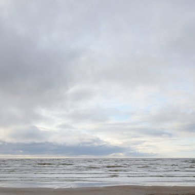 Fırtınadan sonra Baltık Denizi. Yumuşak günbatımı ışığı, çarpıcı parlayan bulutlar. Deniz manzarası, bulutlar, doğa. Panoramik manzara. Ekoloji, iklim değişikliği, hava durumu