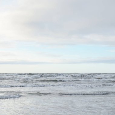 Fırtınadan sonra Baltık Denizi. Yumuşak günbatımı ışığı, çarpıcı parlayan bulutlar. Deniz manzarası, bulutlar, doğa. Panoramik manzara. Ekoloji, iklim değişikliği, hava durumu