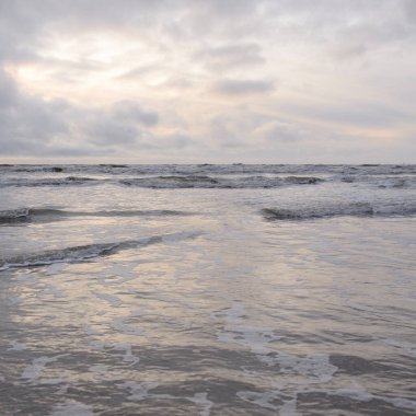 Fırtınadan sonra Baltık Denizi. Yumuşak günbatımı ışığı, çarpıcı parlayan bulutlar. Deniz manzarası, bulutlar, doğa. Sudaki yansımalar. Panoramik manzara. Ekoloji, iklim değişikliği, hava durumu