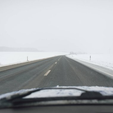 Karla kaplı orman ve kırsal alanda boş otoyol (asfalt yol). Kar fırtınası, kar yağışı. Avrupa. Doğa, Noel tatilleri, uzak yerler, kış lastikleri, tehlikeli sürüş konsepti