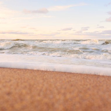 Gün batımında Baltık kıyıları (kum tepeleri). Yumuşak güneş ışığı, parlayan bulutlar, dalgalar ve su fışkıran berrak gökyüzü. Idyllic deniz manzarası. Liepaja, Letonya, Avrupa. Sıcak kış havası, iklim değişikliği, doğa
