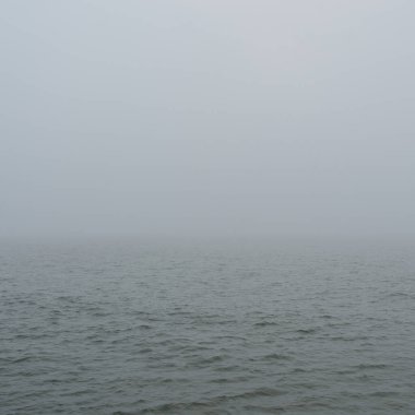 Sis içindeki Baltık Denizi. Dalgalar, su sıçratma, fırtına. Doğal dokular. Resimli panoramik monokrom manzarası, deniz manzarası. Doğa, çevre, sert hava, tehlike
