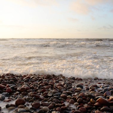Gün batımında Baltık kıyılarından panoramik manzara. Dramatik bulutlar, parlayan bulutlar, fırtınadan sonra altın güneş ışığı. Doğa, çevre, iklim değişikliği, kararsız hava