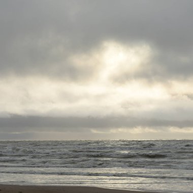 Fırtınadan sonra Baltık Denizi. Yumuşak günbatımı ışığı, çarpıcı parlayan bulutlar. Deniz manzarası, bulutlar, doğa. Panoramik manzara. Ekoloji, iklim değişikliği, hava durumu