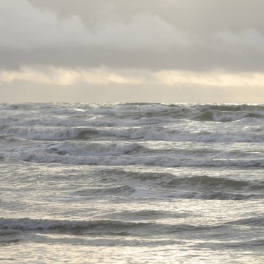 Fırtınadan sonra Baltık Denizi. Yumuşak günbatımı ışığı, çarpıcı parlayan bulutlar. Deniz manzarası, bulutlar, doğa. Panoramik manzara. Ekoloji, iklim değişikliği, hava durumu