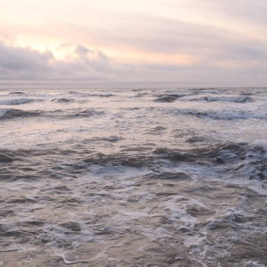 Fırtınadan sonra Baltık Denizi. Yumuşak günbatımı ışığı, çarpıcı parlayan bulutlar. Deniz manzarası, bulutlar, doğa. Panoramik manzara. Ekoloji, iklim değişikliği, hava durumu