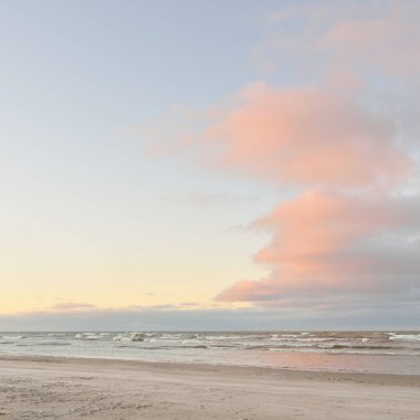 Gün batımında Baltık kıyılarından panoramik manzara. Dramatik bulutlar, parlayan bulutlar, fırtınadan sonra altın güneş ışığı. Doğa, çevre, iklim değişikliği, kararsız hava