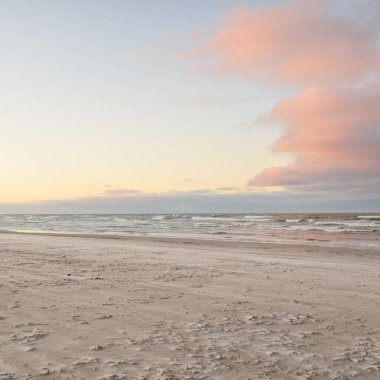 Gün batımında Baltık kıyılarından panoramik manzara. Dramatik bulutlar, parlayan bulutlar, fırtınadan sonra altın güneş ışığı. Doğa, çevre, iklim değişikliği, kararsız hava