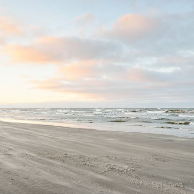 Gün batımında Baltık kıyılarından panoramik manzara. Dramatik bulutlar, parlayan bulutlar, fırtınadan sonra altın güneş ışığı. Doğa, çevre, iklim değişikliği, kararsız hava