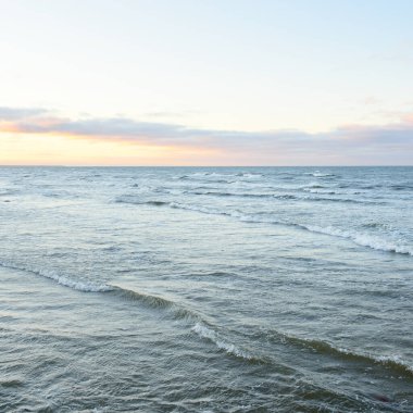 Gün batımında Baltık kıyılarından panoramik manzara. Dramatik bulutlar, parlayan bulutlar, fırtınadan sonra altın güneş ışığı. Doğa, çevre, iklim değişikliği, kararsız hava
