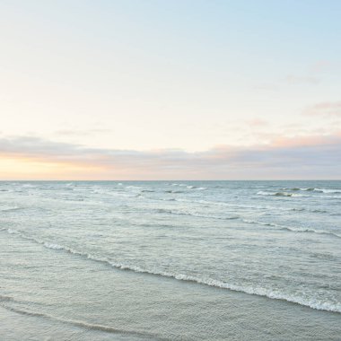 Gün batımında Baltık kıyılarından panoramik manzara. Dramatik bulutlar, parlayan bulutlar, fırtınadan sonra altın güneş ışığı. Doğa, çevre, iklim değişikliği, kararsız hava