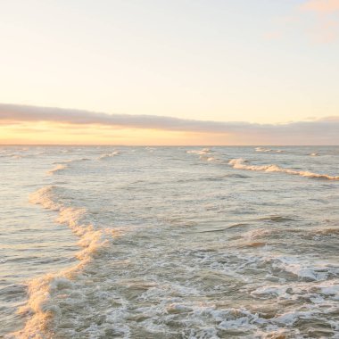 Gün batımında Baltık kıyılarından panoramik manzara. Dramatik bulutlar, parlayan bulutlar, fırtınadan sonra altın güneş ışığı. Doğa, çevre, iklim değişikliği, kararsız hava