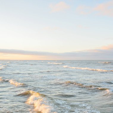 Gün batımında Baltık kıyılarından panoramik manzara. Dramatik bulutlar, parlayan bulutlar, fırtınadan sonra altın güneş ışığı. Doğa, çevre, iklim değişikliği, kararsız hava