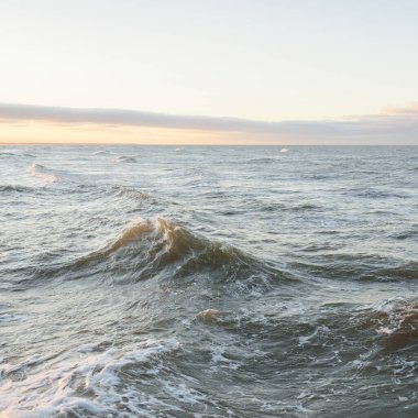 Gün batımında Baltık kıyılarından panoramik manzara. Dramatik bulutlar, parlayan bulutlar, fırtınadan sonra altın güneş ışığı. Doğa, çevre, iklim değişikliği, kararsız hava