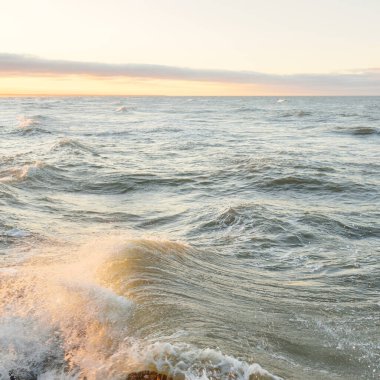 Gün batımında Baltık kıyılarından panoramik manzara. Dramatik bulutlar, parlayan bulutlar, fırtınadan sonra altın güneş ışığı. Doğa, çevre, iklim değişikliği, kararsız hava