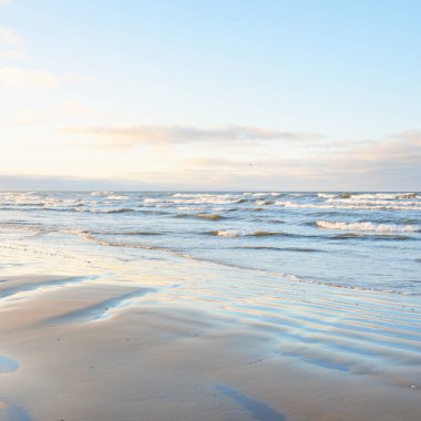 Gün batımında Baltık kıyılarından panoramik manzara. Dramatik bulutlar, parlayan bulutlar, fırtınadan sonra altın güneş ışığı. Doğa, çevre, iklim değişikliği, kararsız hava