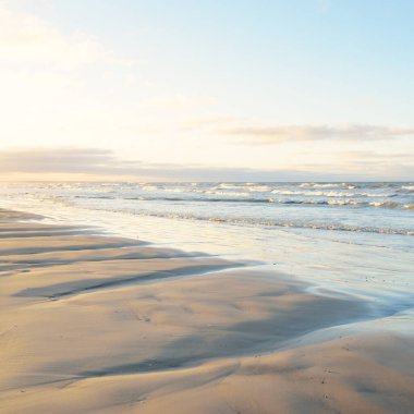 Gün batımında Baltık kıyılarından panoramik manzara. Dramatik bulutlar, parlayan bulutlar, fırtınadan sonra altın güneş ışığı. Doğa, çevre, iklim değişikliği, kararsız hava