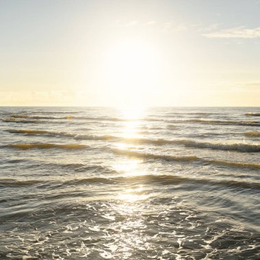 Kumlu bir sahilden (kum tepeleri) Baltık denizinin panoramik görüntüsü. Parlayan bulutlarla, dalgalarla ve su sıçramalarıyla berrak bir gökyüzü. Idyllic deniz manzarası. Sıcak kış havası, iklim değişikliği, doğa