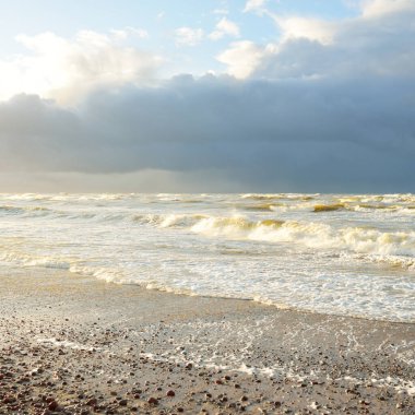 Fırtınadan sonra Baltık kıyıları (kum tepeleri, plaj). Dramatik gökyüzü, parlayan bulutlar. Resimli panoramik manzara. Doğa, çevre, ekoloji, eko-turizm, yürüyüş, keşif kavramları