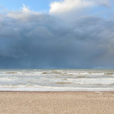 Fırtınadan sonra Baltık kıyıları (kum tepeleri, plaj). Dramatik gökyüzü, parlayan bulutlar. Resimli panoramik manzara. Doğa, çevre, ekoloji, eko-turizm, yürüyüş, keşif kavramları