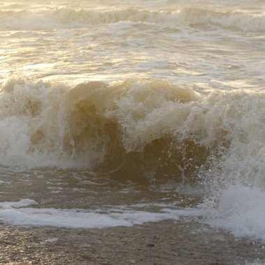 Fırtınadan sonra Baltık kıyıları. Gün batımı, yumuşak güneş ışığı. Su yüzeyi dokusu, çarpan dalgalar, sıçramalar, köpük. Resimli panoramik manzara. Idyllic deniz manzarası. Doğa, çevre, ekoloji temaları