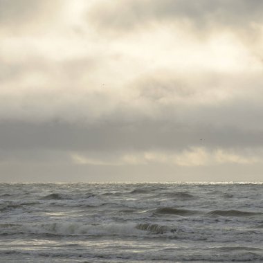 Fırtınadan sonra Baltık Denizi. Yumuşak günbatımı ışığı, çarpıcı parlayan bulutlar. Deniz manzarası, bulutlar, doğa. Panoramik manzara. Ekoloji, iklim değişikliği, hava durumu
