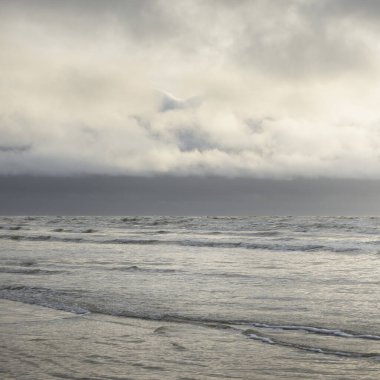 Fırtınadan sonra Baltık Denizi. Yumuşak günbatımı ışığı, çarpıcı parlayan bulutlar. Deniz manzarası, bulutlar, doğa. Panoramik manzara. Ekoloji, iklim değişikliği, hava durumu