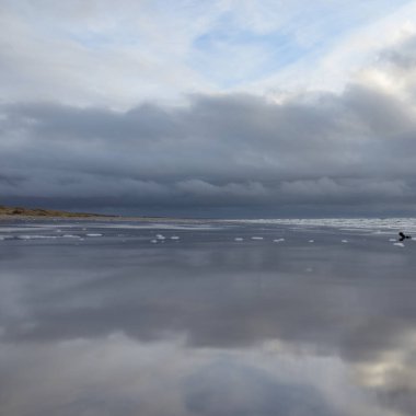 Fırtınadan sonra Baltık Denizi. Yumuşak günbatımı ışığı, çarpıcı parlayan bulutlar. Deniz manzarası, bulutlar, doğa. Sudaki yansımalar. Panoramik manzara. Ekoloji, iklim değişikliği, hava durumu