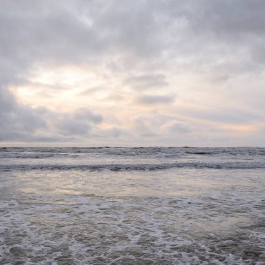 Fırtınadan sonra Baltık Denizi. Yumuşak günbatımı ışığı, çarpıcı parlayan bulutlar. Deniz manzarası, bulutlar, doğa. Sudaki yansımalar. Panoramik manzara. Ekoloji, iklim değişikliği, hava durumu