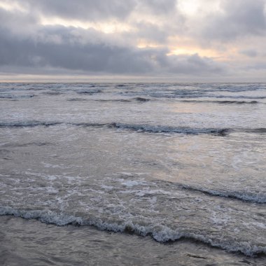 Fırtınadan sonra Baltık Denizi. Yumuşak günbatımı ışığı, çarpıcı parlayan bulutlar. Deniz manzarası, bulutlar, doğa. Panoramik manzara. Ekoloji, iklim değişikliği, hava durumu