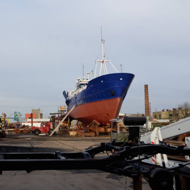 Karada duran eski gemi. Liman, tersane. Sanayi bölgesi. Ulaşım, onarım, servis. Havalandırma, Letonya, Baltık Denizi