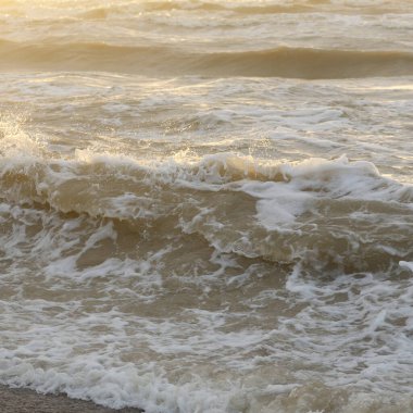 Fırtınadan sonra Baltık kıyıları. Gün batımı, yumuşak güneş ışığı. Su yüzeyi dokusu, çarpan dalgalar, sıçramalar, köpük. Resimli panoramik manzara. Idyllic deniz manzarası. Doğa, çevre, ekoloji temaları