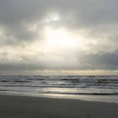 Fırtınadan sonra Baltık Denizi. Yumuşak günbatımı ışığı, çarpıcı parlayan bulutlar. Deniz manzarası, bulutlar, doğa. Panoramik manzara. Ekoloji, iklim değişikliği, hava durumu