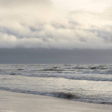 Fırtınadan sonra Baltık Denizi. Yumuşak günbatımı ışığı, çarpıcı parlayan bulutlar. Deniz manzarası, bulutlar, doğa. Panoramik manzara. Ekoloji, iklim değişikliği, hava durumu