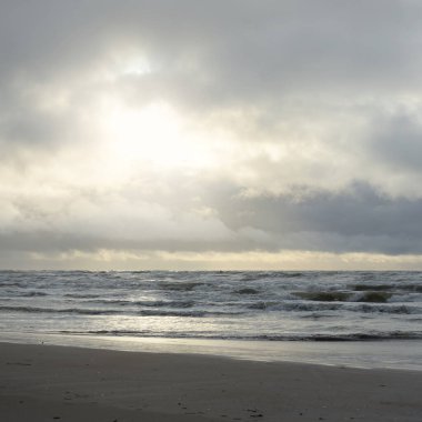 Fırtınadan sonra Baltık Denizi. Yumuşak günbatımı ışığı, çarpıcı parlayan bulutlar. Deniz manzarası, bulutlar, doğa. Panoramik manzara. Ekoloji, iklim değişikliği, hava durumu