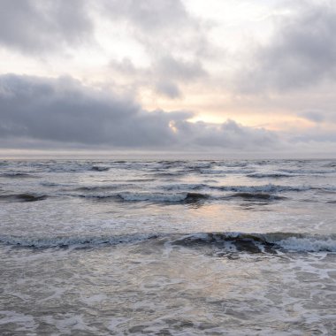 Fırtınadan sonra Baltık Denizi. Yumuşak günbatımı ışığı, çarpıcı parlayan bulutlar. Deniz manzarası, bulutlar, doğa. Panoramik manzara. Ekoloji, iklim değişikliği, hava durumu