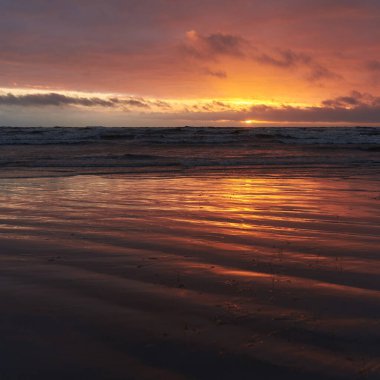 Fırtınadan sonra gün batımında Baltık Denizi. Dramatik gökyüzü, parlayan bulutlar, dofty altın güneş ışığı, dalgalar, fışkıran su. Resimli panoramik manzara. Doğa, çevre, ekoloji