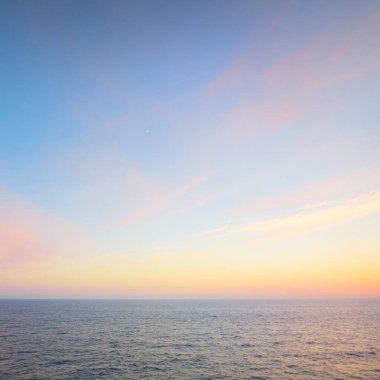 Gün batımında Baltık Denizi. Açık gökyüzü, mavi ve pembe parlayan bulutlar, yumuşak altın güneş ışığı. Su yüzeyi dokusu. Deniz manzarası, bulutlar, doğa gibi hayali görüntüler. Panoramik yaşam