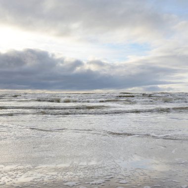 Fırtınadan sonra Baltık Denizi. Yumuşak günbatımı ışığı, çarpıcı parlayan bulutlar. Deniz manzarası, bulutlar, doğa. Panoramik manzara. Ekoloji, iklim değişikliği, hava durumu