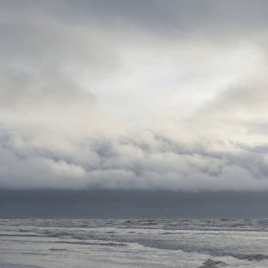 Fırtınadan sonra Baltık Denizi. Yumuşak günbatımı ışığı, çarpıcı parlayan bulutlar. Deniz manzarası, bulutlar, doğa. Panoramik manzara. Ekoloji, iklim değişikliği, hava durumu