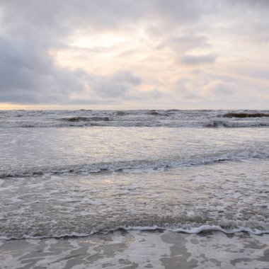 Fırtınadan sonra Baltık Denizi. Yumuşak günbatımı ışığı, çarpıcı parlayan bulutlar. Deniz manzarası, bulutlar, doğa. Sudaki yansımalar. Panoramik manzara. Ekoloji, iklim değişikliği, hava durumu