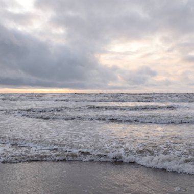 Fırtınadan sonra Baltık Denizi. Yumuşak günbatımı ışığı, çarpıcı parlayan bulutlar. Deniz manzarası, bulutlar, doğa. Sudaki yansımalar. Panoramik manzara. Ekoloji, iklim değişikliği, hava durumu
