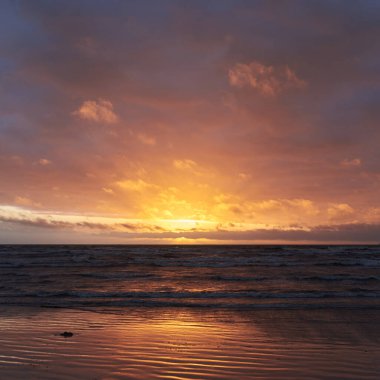 Fırtınadan sonra gün batımında Baltık Denizi. Dramatik gökyüzü, parlayan bulutlar, dofty altın güneş ışığı, dalgalar, fışkıran su. Resimli panoramik manzara. Doğa, çevre, ekoloji