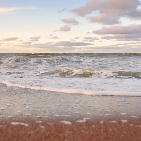 Gün batımında Baltık kıyıları (kum tepeleri). Yumuşak güneş ışığı, parlayan bulutlar, dalgalar ve su fışkıran berrak gökyüzü. Idyllic deniz manzarası. Liepaja, Letonya, Avrupa. Sıcak kış havası, iklim değişikliği, doğa
