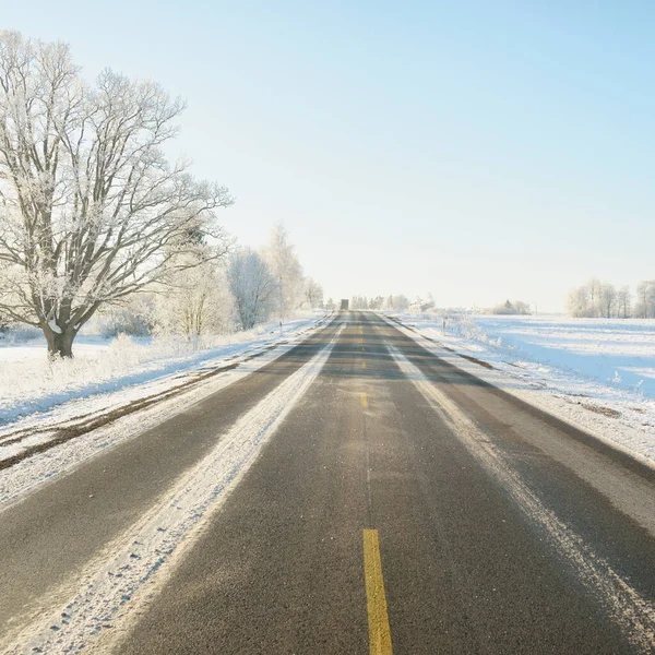 雪に覆われた森林やフィールド 農村部を介して空の高速道路 アスファルト道路 雪のドリフト ヨーロッパだ クリスマス休暇 遠隔地 冬のタイヤ 危険な運転の概念 — ストック写真