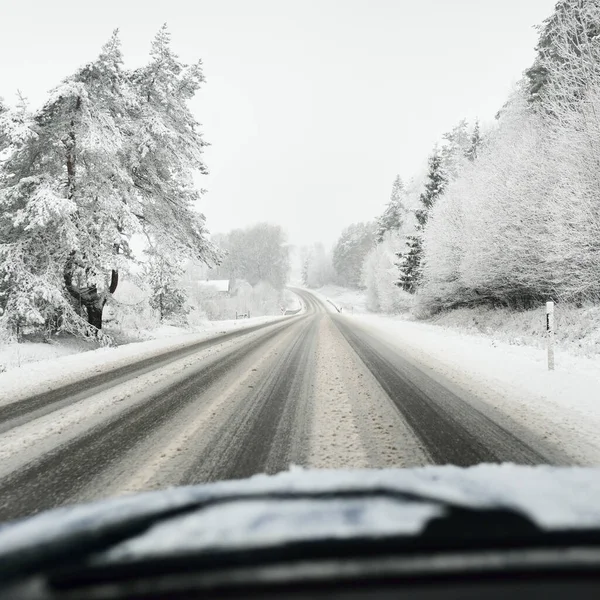 Boş otoyol (asfalt yol) karla kaplı ormanın içinden, kırsal alanda. Arabadan bak. Avrupa. Doğa, Noel tatilleri, uzak yerler, kış lastikleri, tehlikeli sürüş konsepti