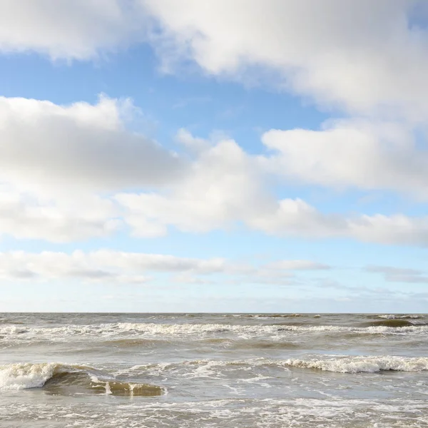 Fırtınadan sonra Baltık Denizi. Dramatik gökyüzü, parlayan bulutlar, yumuşak güneş ışığı. Dalgalar, su sıçratma. Resimli manzara, deniz manzarası, doğa. Panoramik görünüm