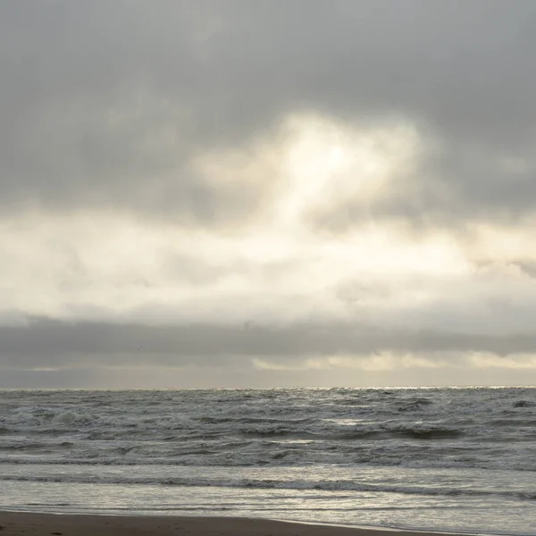 Fırtınadan sonra Baltık Denizi. Yumuşak günbatımı ışığı, çarpıcı parlayan bulutlar. Deniz manzarası, bulutlar, doğa. Panoramik manzara. Ekoloji, iklim değişikliği, hava durumu