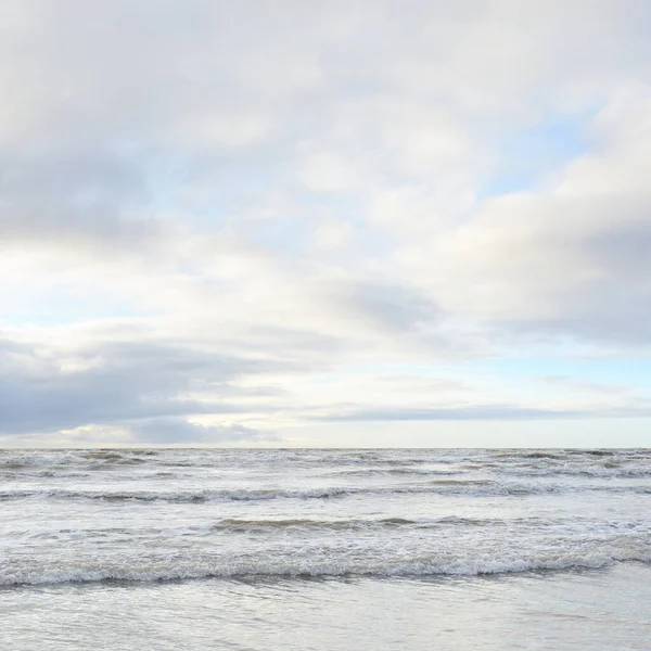Fırtınadan sonra Baltık Denizi. Yumuşak günbatımı ışığı, çarpıcı parlayan bulutlar. Deniz manzarası, bulutlar, doğa. Panoramik manzara. Ekoloji, iklim değişikliği, hava durumu